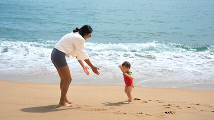 parent and child have healthy recreation walking in the sea in thailand
