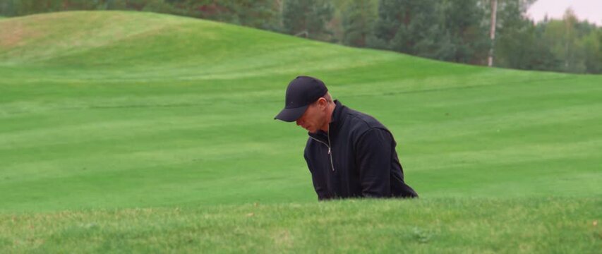 MED Caucasian male playing a bunker shot during a golf game. Super slow motion shot