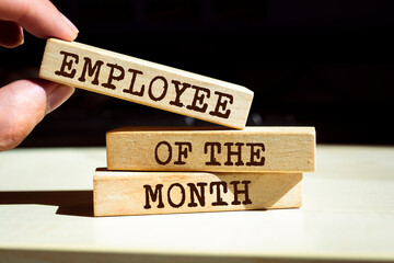 Wooden blocks with words 'Employee of the Month'.