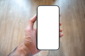 Close up men using a smartphone with an empty white screen at the wooden interior cafe.