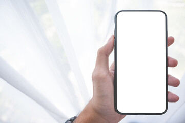 Close up men using a smartphone with an empty white screen at home with window light.