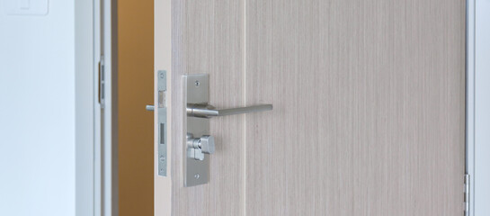 Closeup doorknob of wooden door between open or close the door