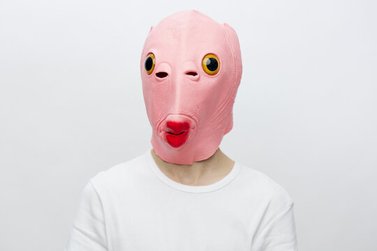 horizontal portrait of a man in a strange pink rubber mask