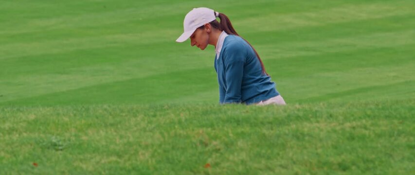 MED Caucasian female playing a bunker shot during a golf game. Super slow motion shot