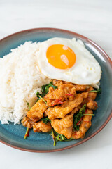 stir-fried fried fish with basil and fried egg topped on rice