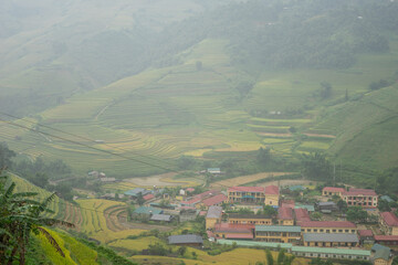 Obraz premium Aerial view of golden rice terraces at Mu cang chai town near Sapa city, north of Vietnam. Beautiful terraced rice field in harvest season in Yen Bai, Vietnam