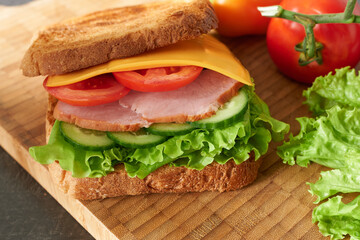 A yummy sandwich with juicy lettuce leaves, close-up. 