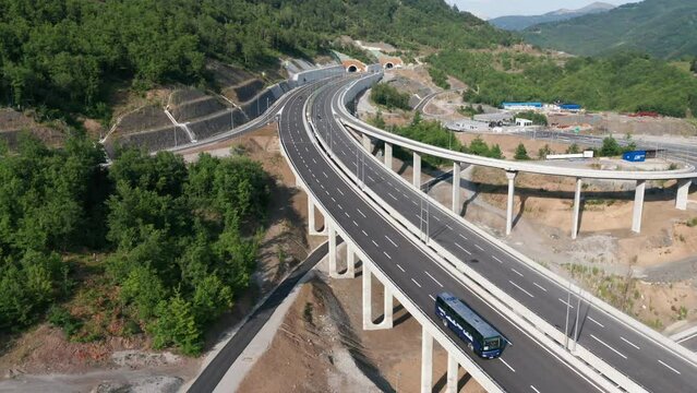 Highway interchange and off ramp on the new freeway in Montenegro. Grade-separated junction allows movement of traffic by using interconnecting roadways. Aerial drone view.