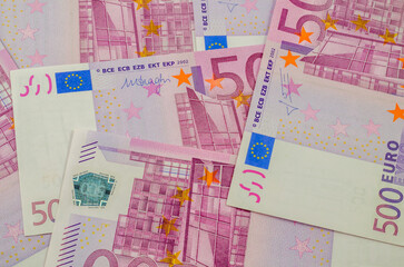 500 euro bills are lying on the table in large quantities.