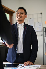 Smart Asian businessman manager shaking hand with his business partner.
