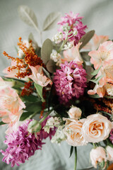 delicate bouquet of flowers in pink tones: roses, hyacinths, peony roses, bush rose, greenery. trends in bouquets. vertically, selective focus