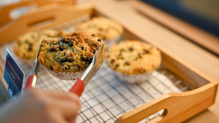 close-up, A female customer buying a wholewheat muffin with raisins in pastry shop
