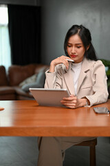 Professional Asian businesswoman concentrating on her business tasks on her tablet.