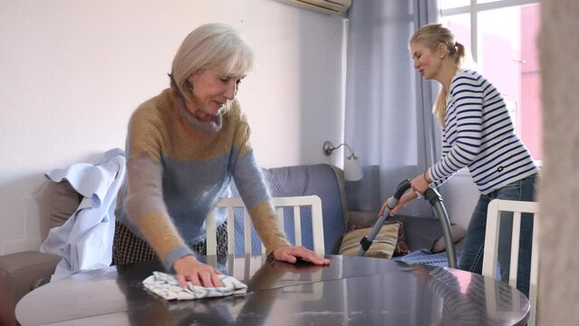 Mature woman cleaning table with rag at home . High quality 4k footage