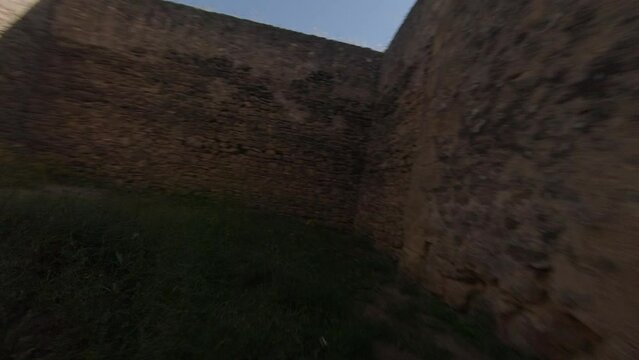 FPV aerial flies through hole blasted into thick Spanish castle wall