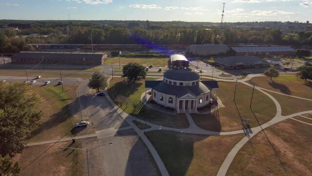 aerial footage of a gorgeous autumn landscape at Carolyn Crayton Park at sunset with yellow winter grass and lush green trees and plants with blue sky and clouds in Macon Georgia USA