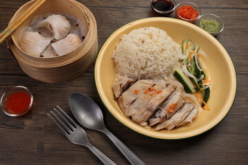 steamed Hainanese chicken rice crystal har gow transparent prawn shrimp meat stuffed dim sum in bamboo steamer green red chilli ginger soya sauce cucumber carrot on retro enamel diner plate fork spoon