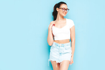 Young beautiful smiling female in trendy summer jeans skirt and top  clothes. Sexy carefree woman...