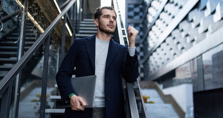 a male cybersecurity specialist in a business suit on the background of the stairs of an office building