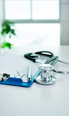 Stethoscope and medical clipboard  on doctor desk