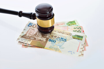 Law gavel on Hong Kong money against white background