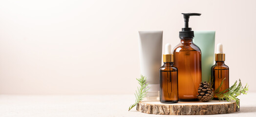 Set of beauty cosmetics on wooden podium with green branches and bump. Concept of winter skin care, cosmetic gifts for Christmas and New Year. Banner