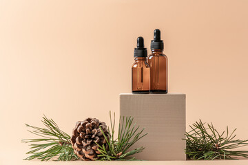 Cosmetics for skin care in the cold season. Serums in dark glass bottles on wooden cube podium with...