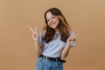 White preteen girl wearing t-shirt smiling and gesturing at camera