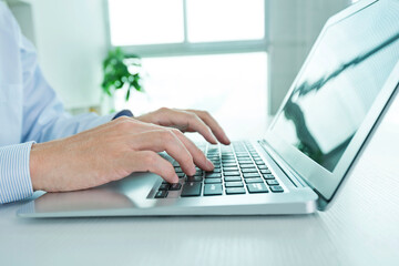 Close-up of businessman using laptop computer in office