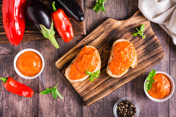 Ajvar delicious appetizer of pepper, eggplant and garlic on bread and in bowls. Top view