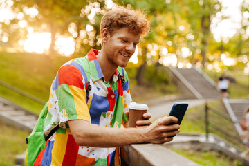 Young handsome smiling happy man in colorful shirt with coffee