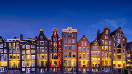 Fototapeta na wymiar Amsterdam, Netherlands. View of houses during sunset. The famous Dutch canals. A cityscape in the evening. Travel photography.