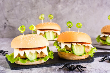 Monster burgers for halloween menu on slate and spiders. Home made creative food.