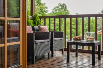 A wooden cottage in a forest with beautiful terrace and table with two armchairs. Cozy and nice house in a french village