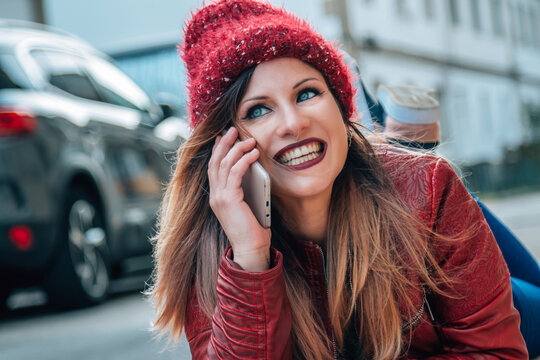 beautiful happy young girl talking with smartphone on the street
