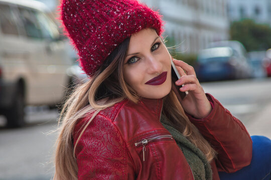 beautiful stylish smiling young woman with phone on the street