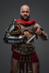 Portrait of bearded gladiator dressed in armor and red cloak holding two swords.
