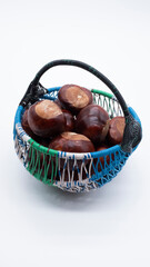 Chestnuts conkers brown in decorative small basket