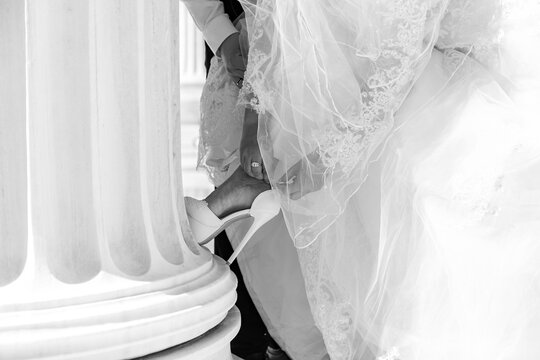 White and black photo of bride shoes