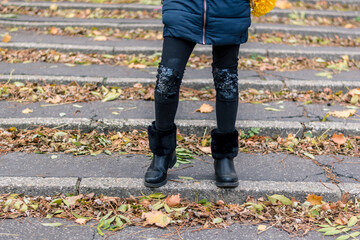 black shoes and autumnal leaves on staircase