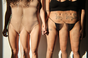 Horizontal medium section multiple exposure studio shot of unrecognizable young women in underwear holding hands 