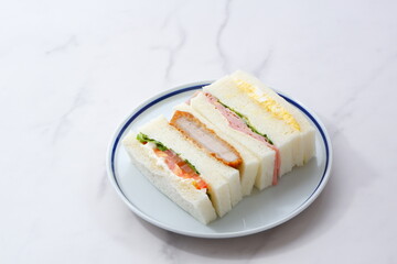 トンカツやタマゴ、ハム、生野菜のサンドイッチ