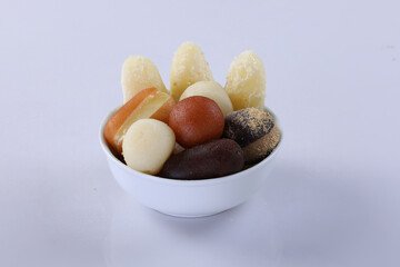 Various types of sweets in a bowl isolated on white