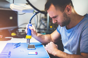 Man repairing mobile phone electronics service shop