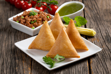 Fried indian dish samosha.Indian Delicious Deep Fried Breakfast Samosa Also Know as Samoosa isolated on Wooden texture Background