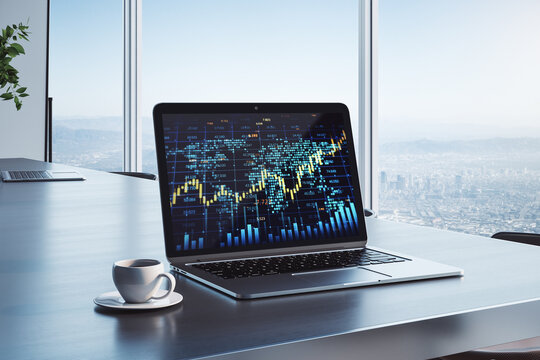 workplace with creative forex chart with candlestick graph, index and tech hologram on laptop screen, coffee cup on office background with window and blurry city view. 