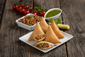 Fried indian dish samosha.Indian Delicious Deep Fried Breakfast Samosa Also Know as Samoosa isolated on Wooden texture Background