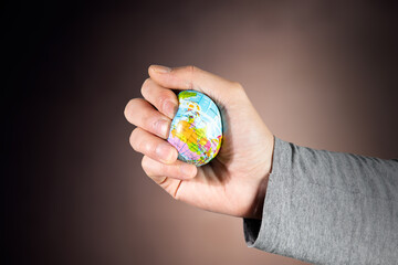 Presses a globe in his hand