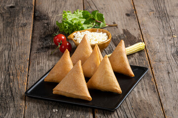 Sweet, tasty, fried indian dish samosha.Indian Delicious Deep Fried Breakfast Samosa Also Know as Samoosa isolated on Wooden texture Background