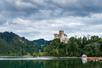 Fototapeta na wymiar View of the beautiful castle in Niedzica. Castle on a hill above the lake surrounded by rocky mountains. Niedzica, Poland